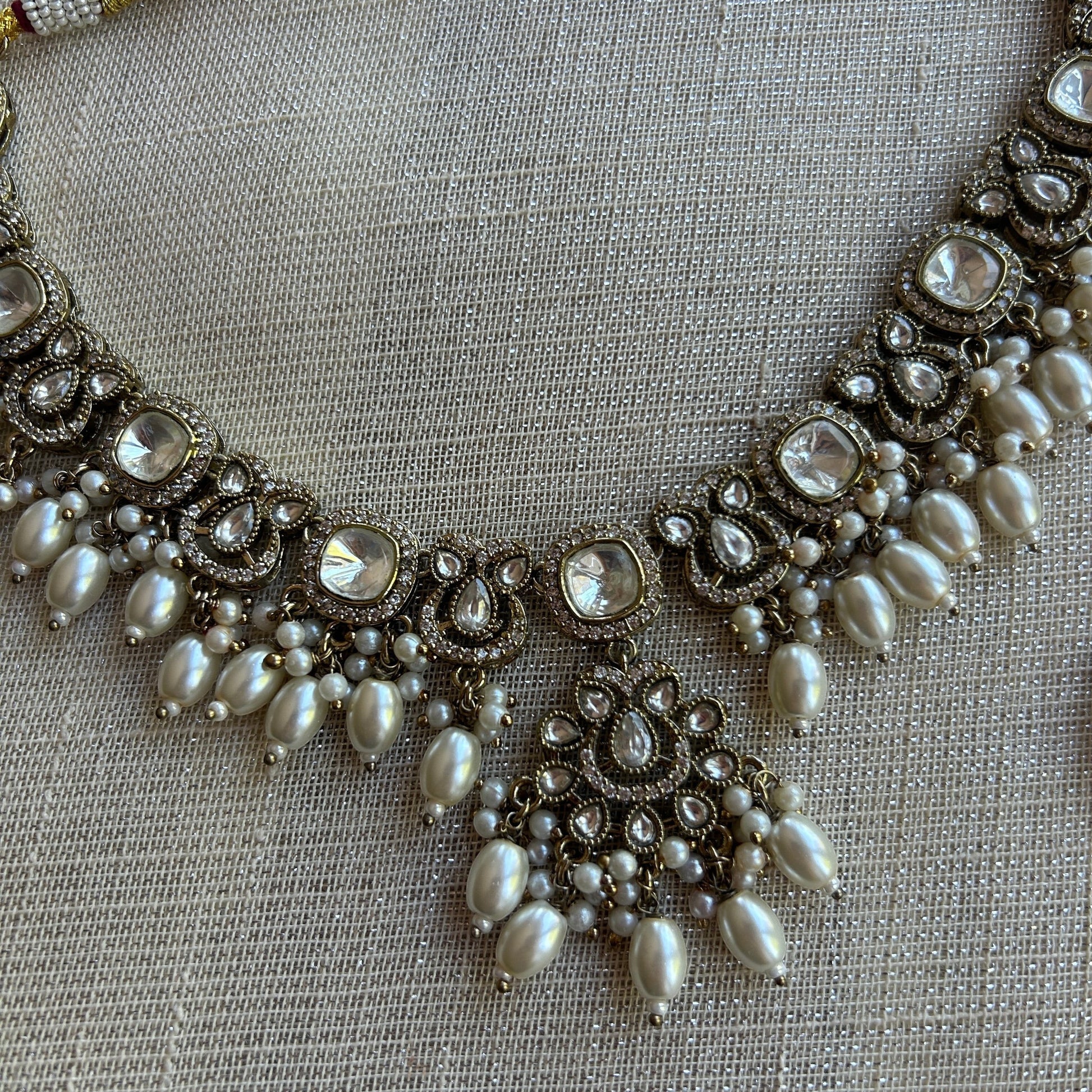 The Jewel Project antique gold necklace set with clear stones and pearls, matching Chandbali earrings.