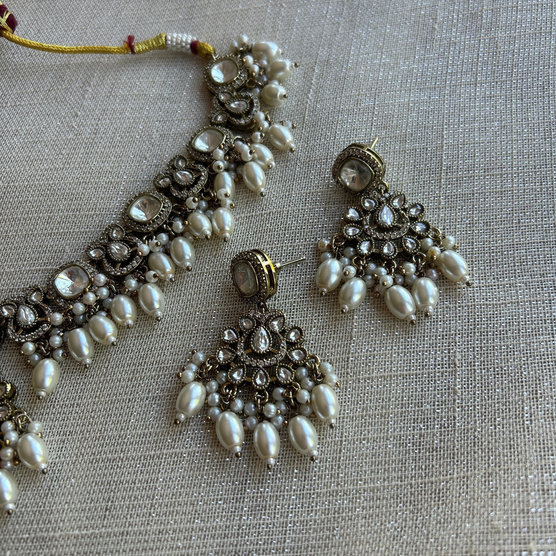 The Jewel Project silver pearl necklace set with matching Chandbali earrings, featuring clear stones and pearl drops.